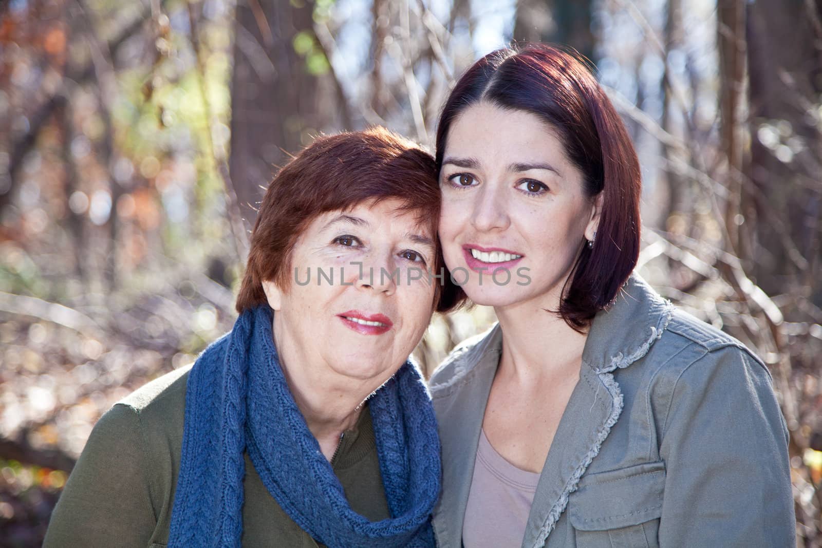 Women - adult daughter and mother - smiling and looking at the camera.