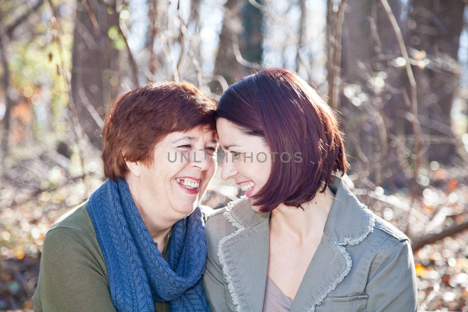 Intimate portrait of women (mother and daughter) laughing at each other with love and affection.