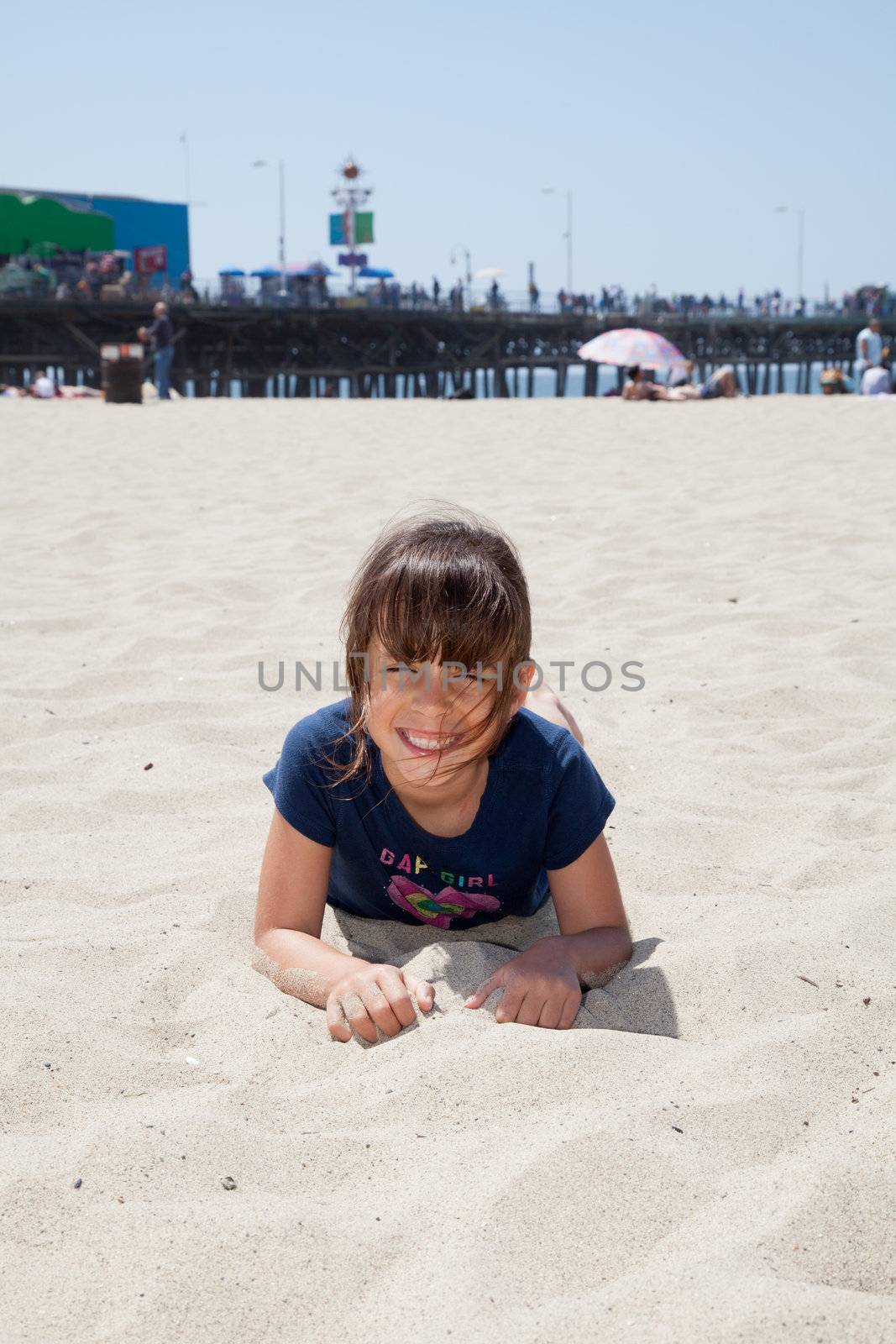 Little girl relaxing on the beach and playing with sand.
