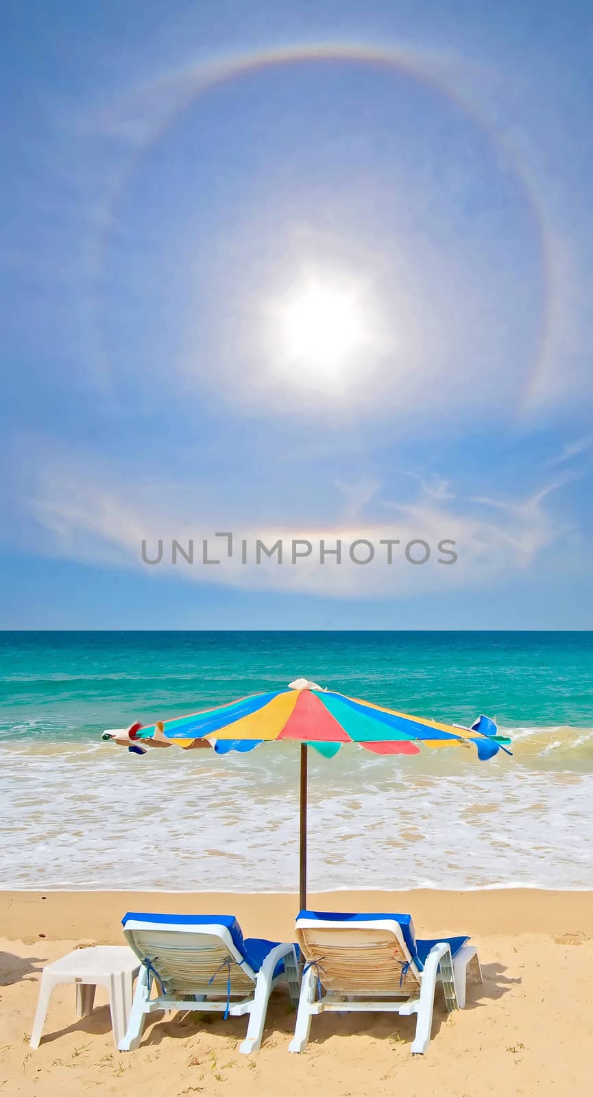 Couple chair and multi-color umbrella on the beach with perfectly sky