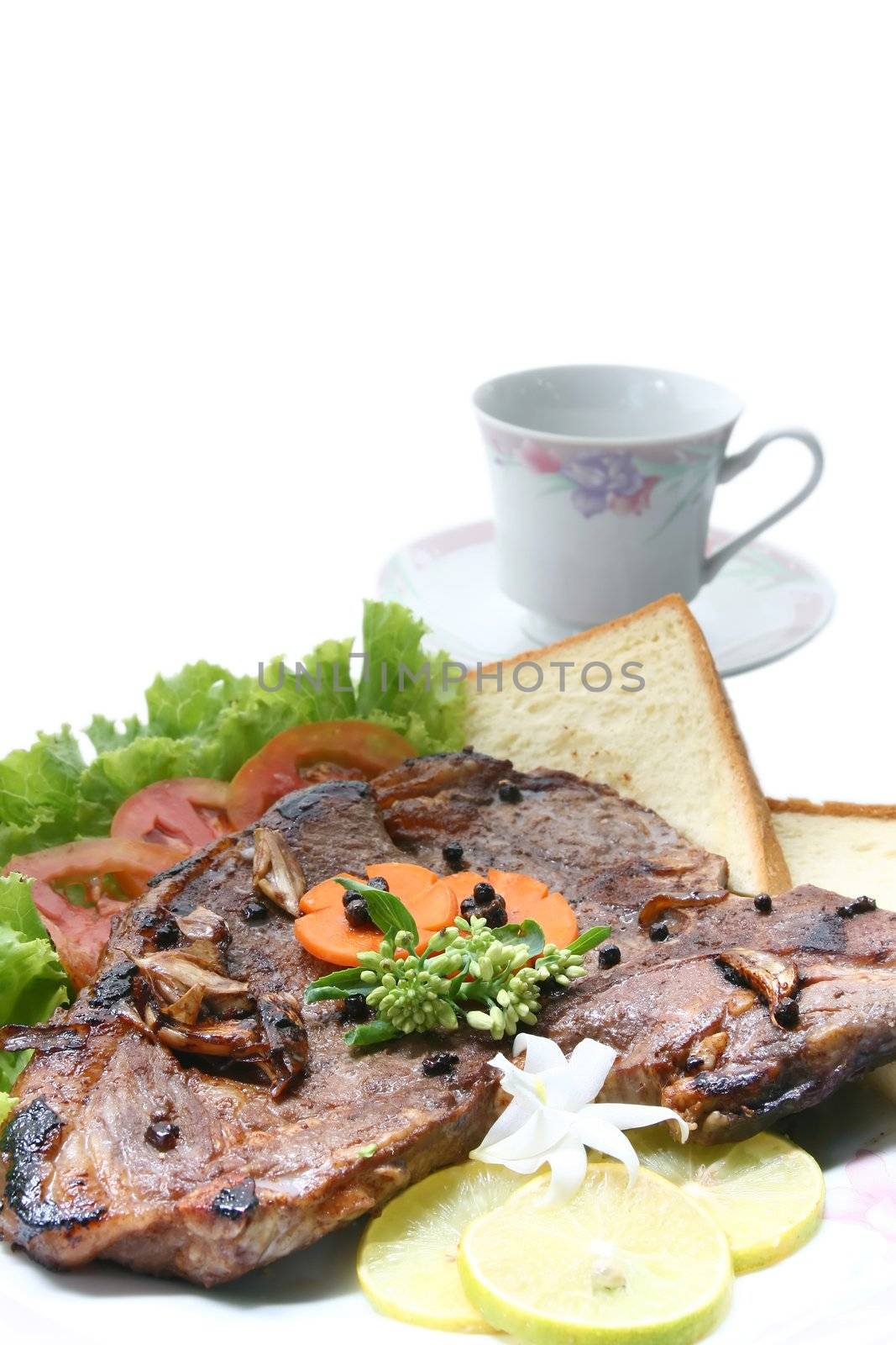 closeup of T Bone Pepper Steak dressing by vegetable and bread  with Coffee cup