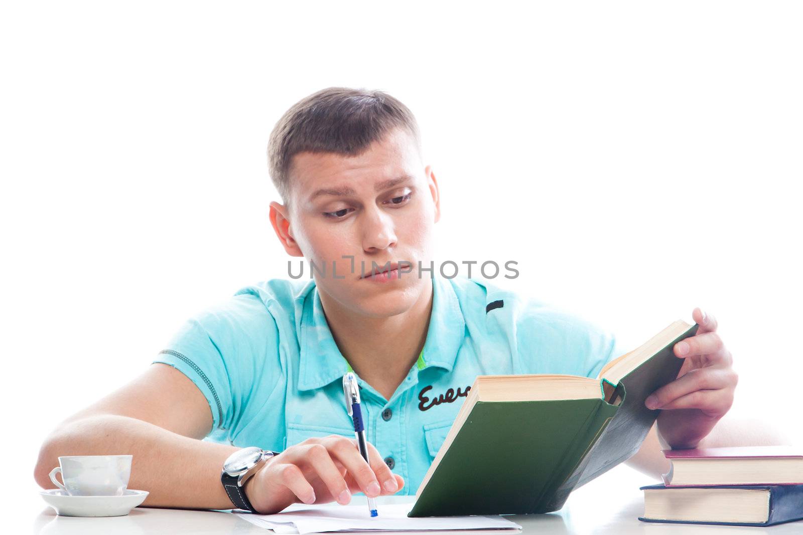 Portrait of a young attractive guy who is preparing for the exams at a university or college