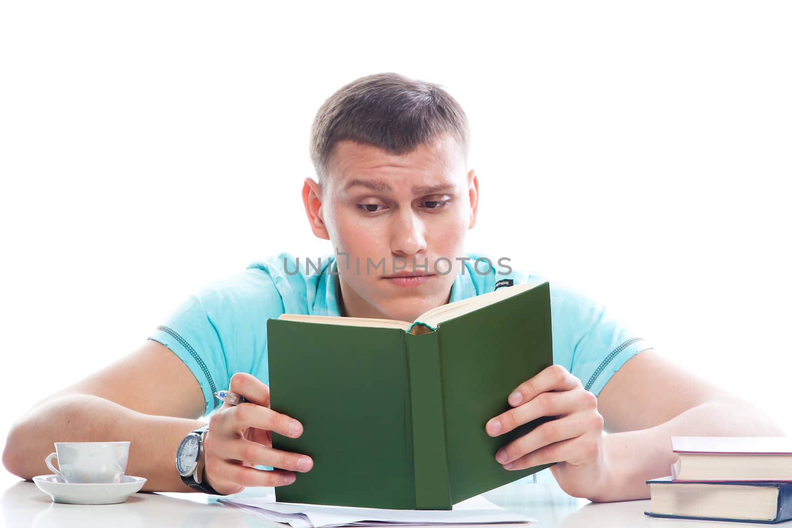Portrait of a young attractive guy who is preparing for the exams at a university or college