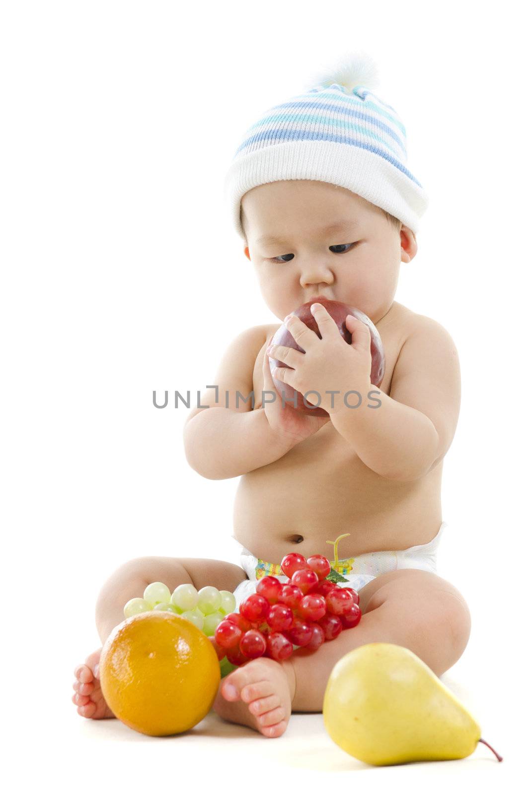 Pan Asian baby playing with fruits on white background