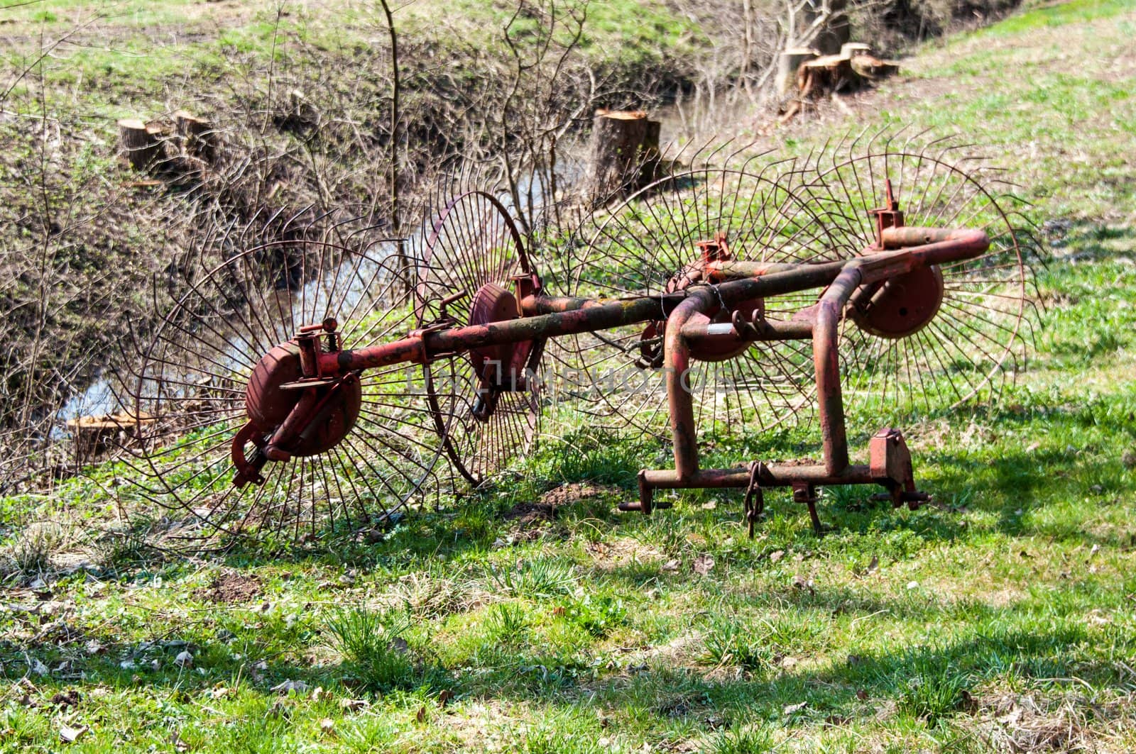 blades of an old hay rake left on a meadow field