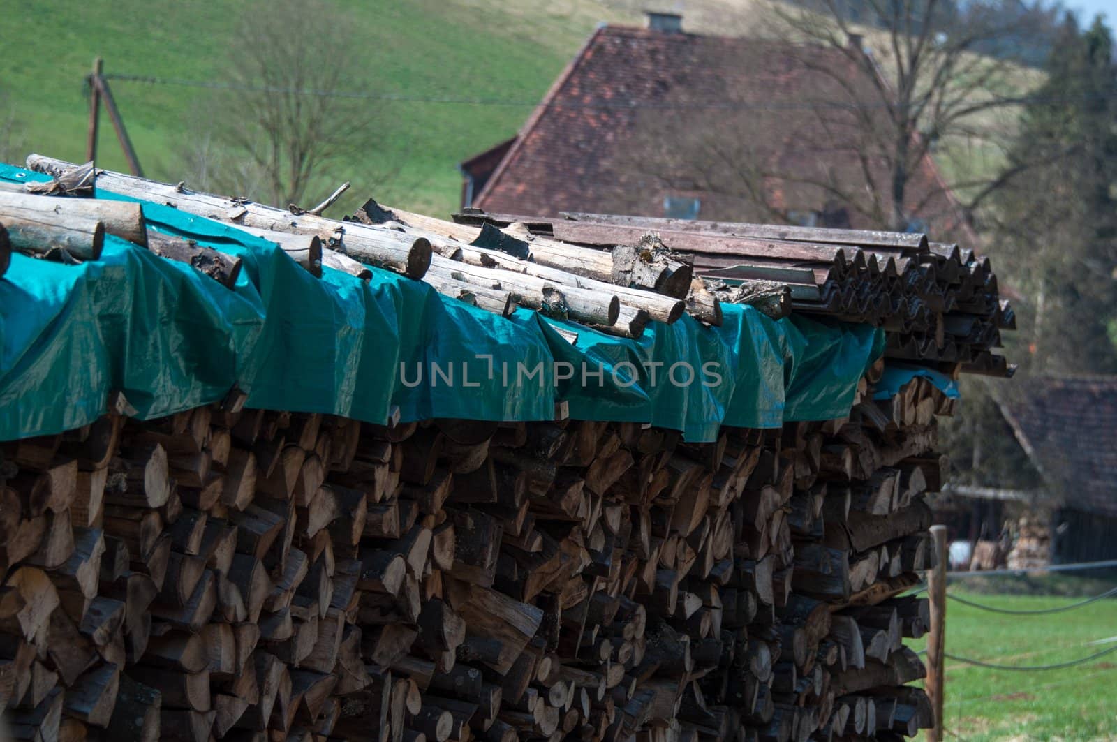 Image of a pile of firewood and old farmhouse