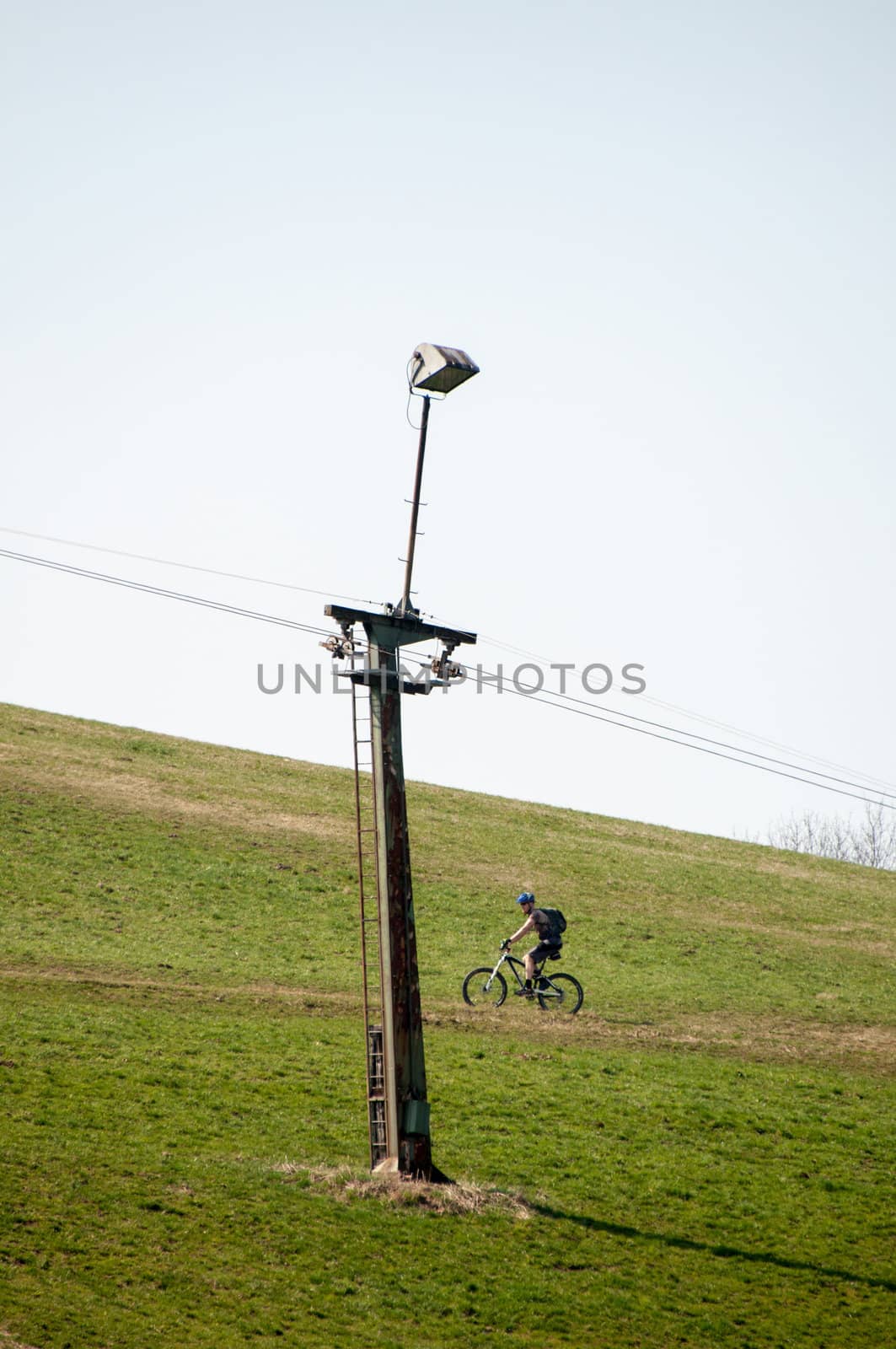 skilift in the mountains on a green lawn during the summer with mountain biker