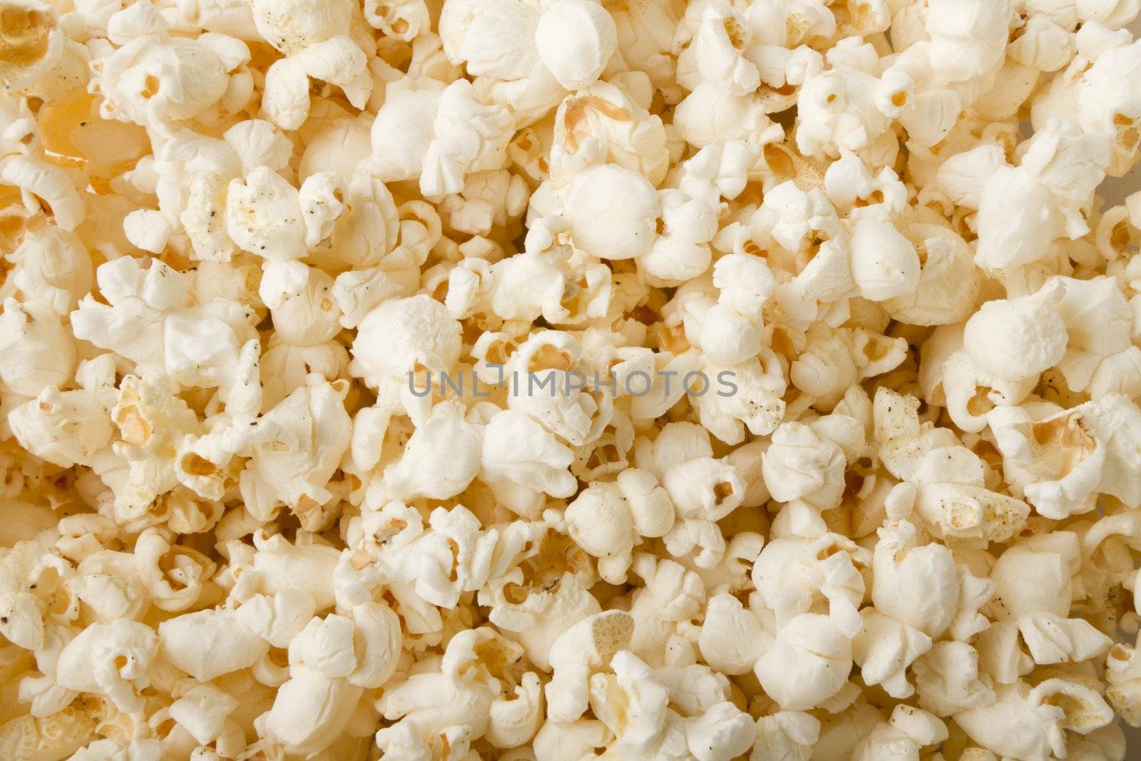 close up of popcorn with salt and pepper and lightly buttered and ready for a movie