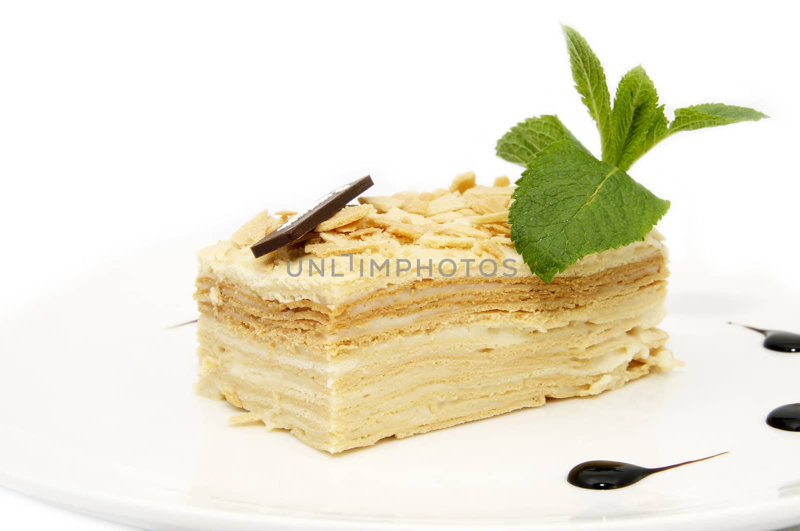 piece of layer cake decorated with a mint on a white plate