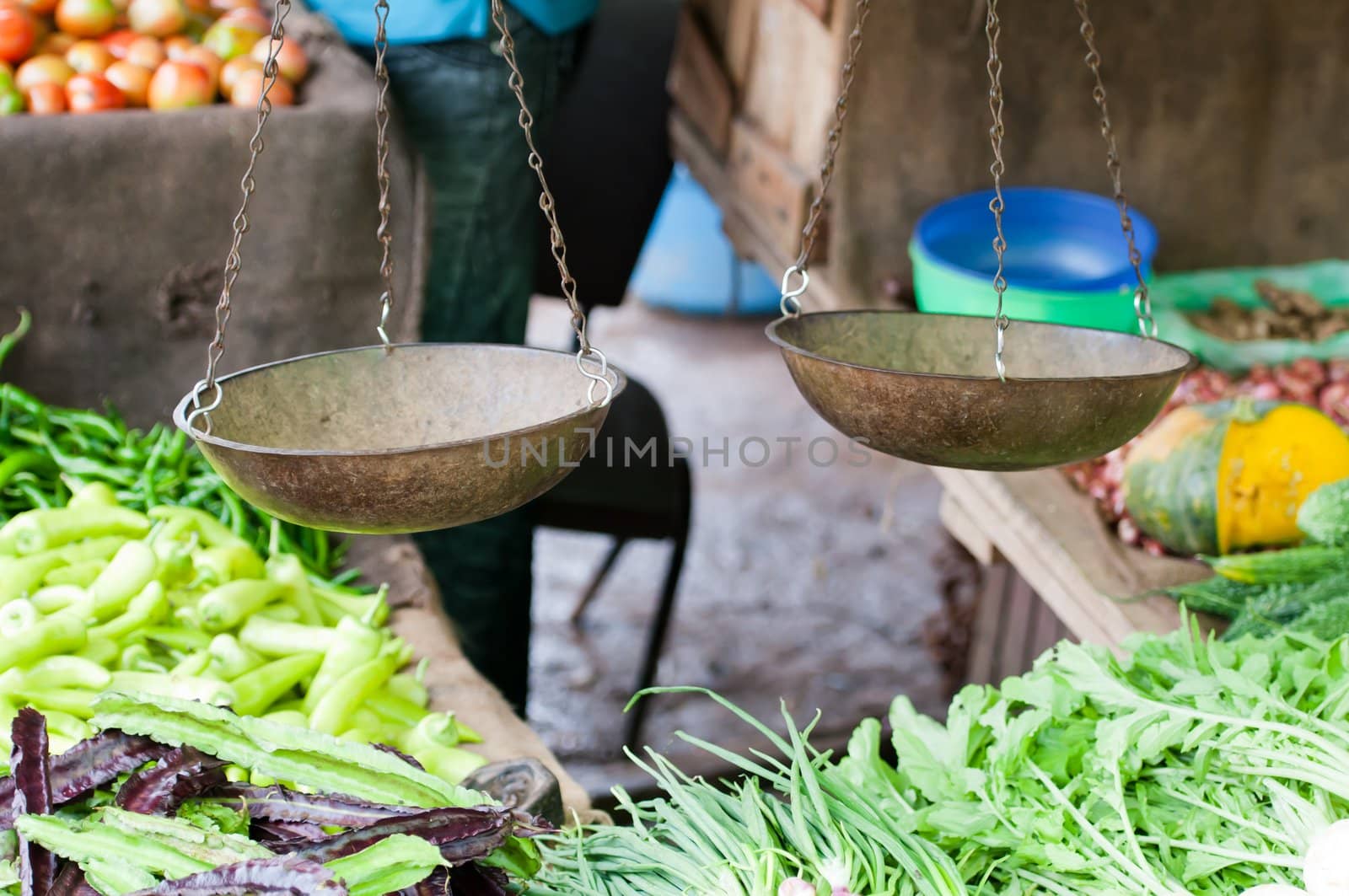 Old scales on open market with vegetables on shelves. Selective focus on the scales.
