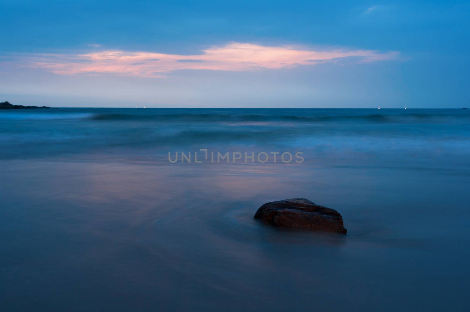 Beautiful stones and mythic waves at night under blue sky