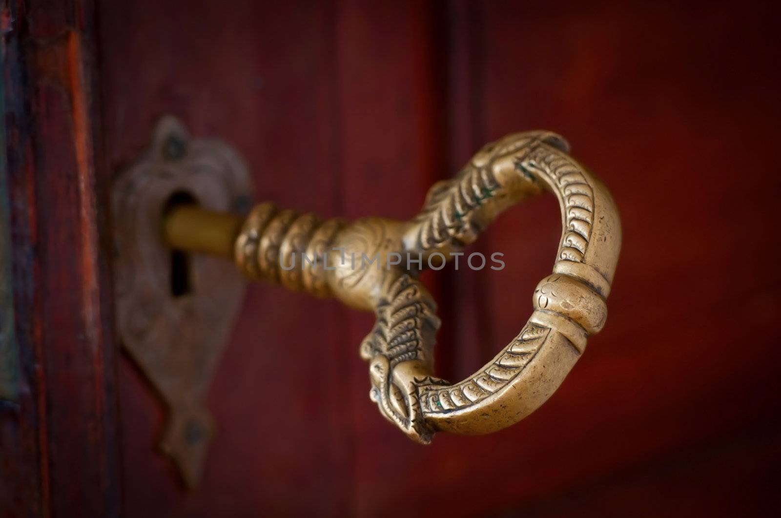 Antique beautiful bronze key in a door by iryna_rasko