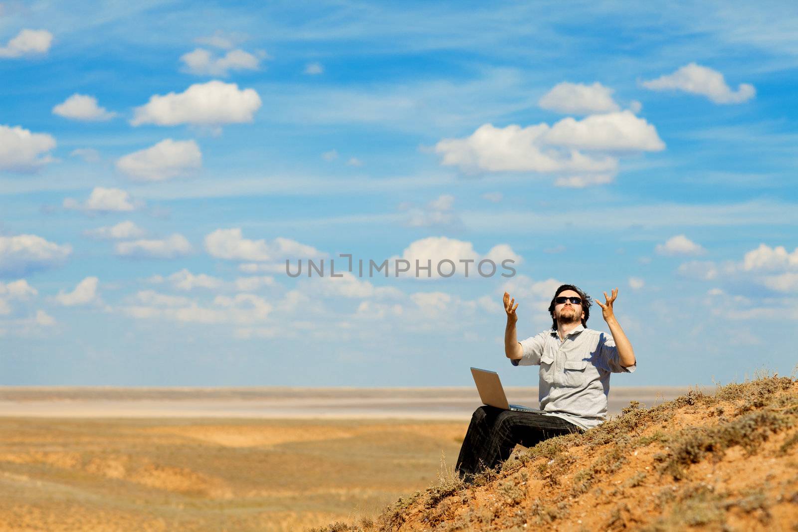 man with laptop praying to the God by vsurkov