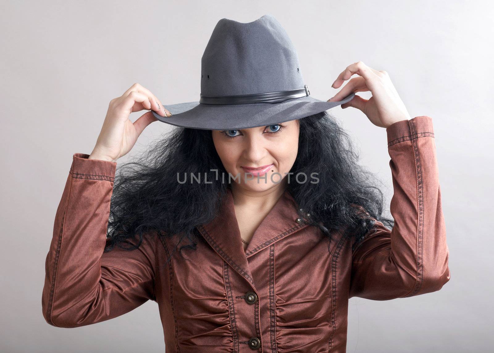 A beautiful girl holding her grey hat