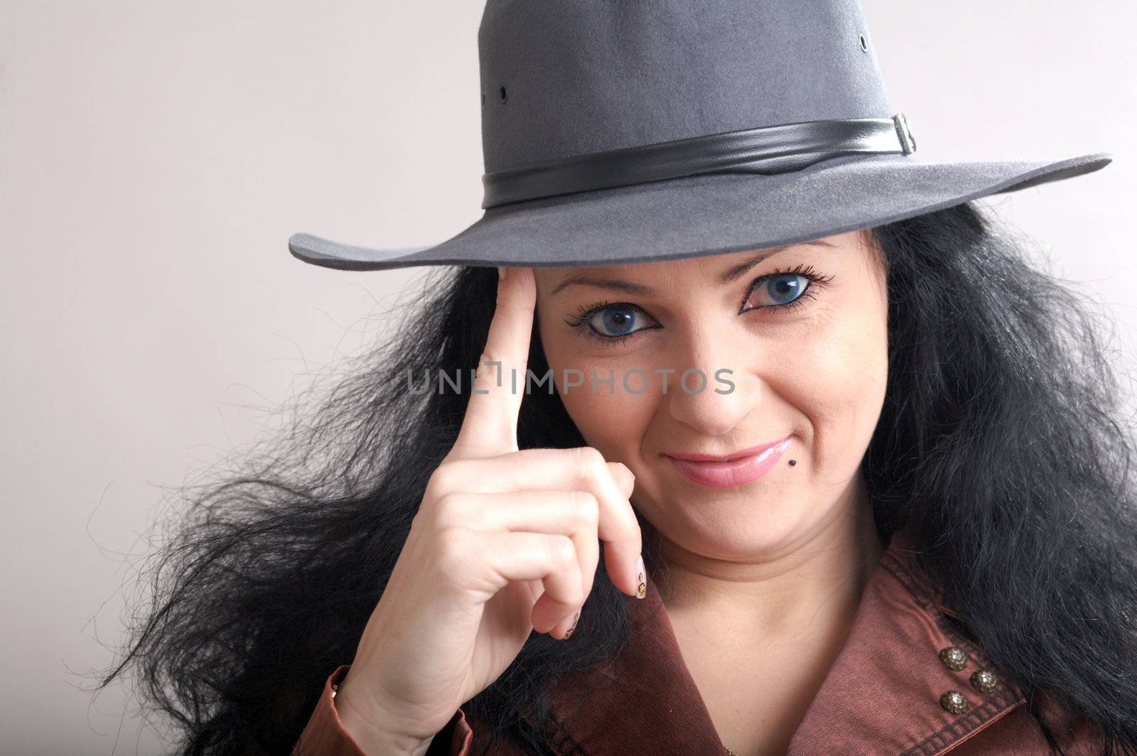 A girl touching her grey hat with her finger