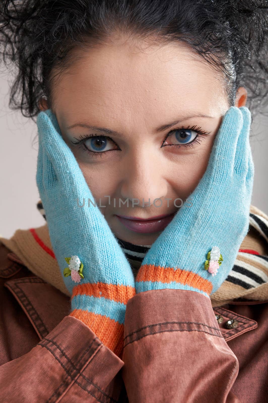 A girl in a striped scarf and blue gloves