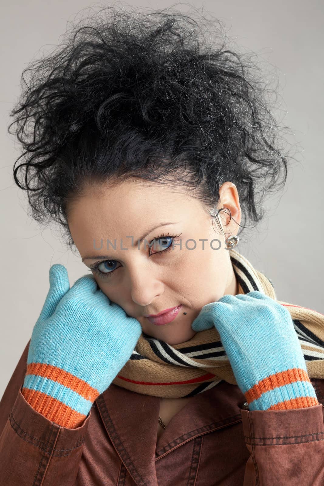 An image of girl in a striped scarf and blue gloves