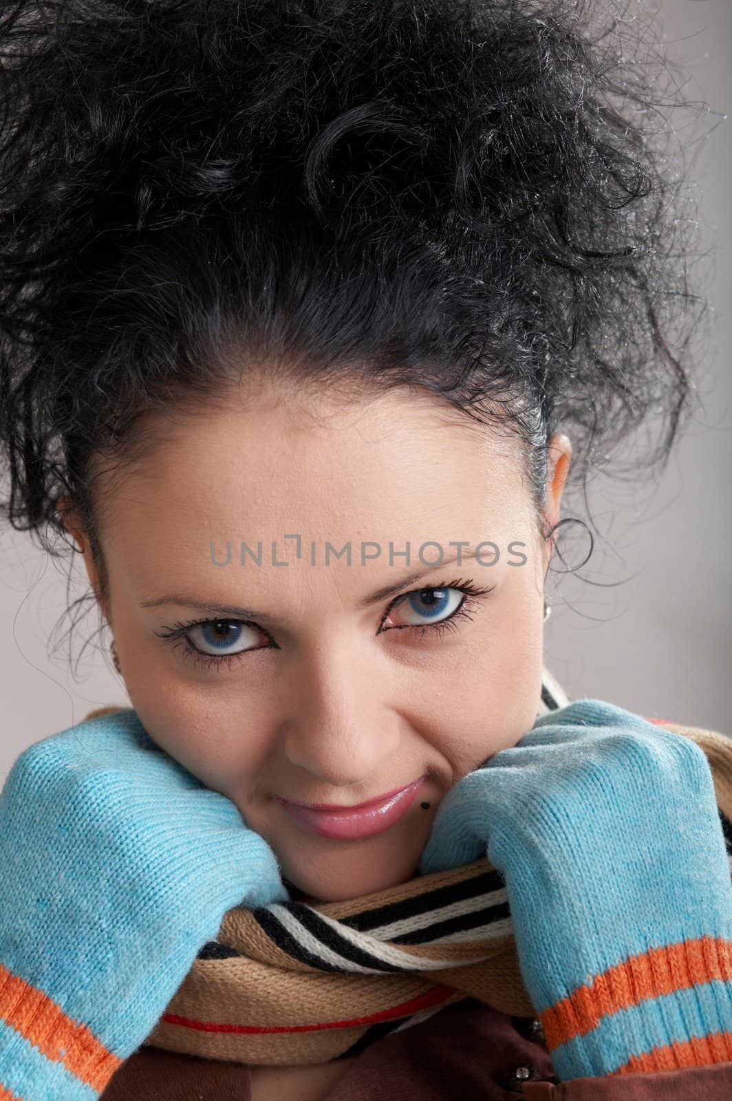 An image of a smiling girl in blue gloves