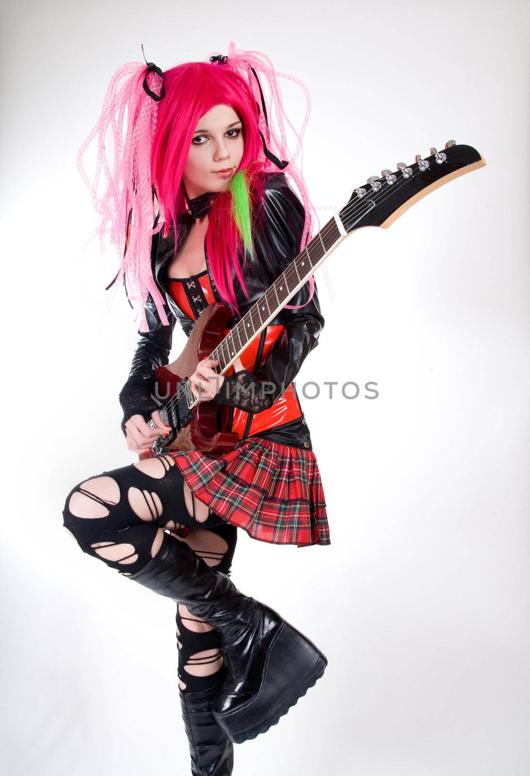 Alternative fashion girl playing guitar, studio shot    