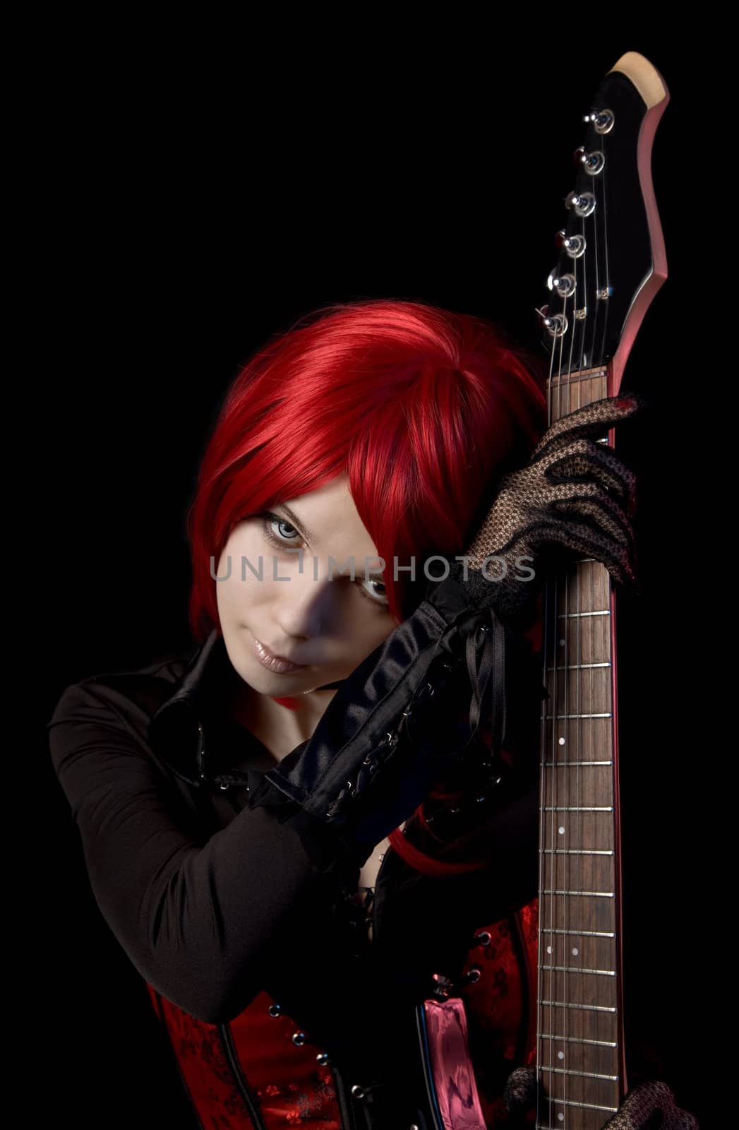 Sexy red haired girl with guitar, isolated on black background  