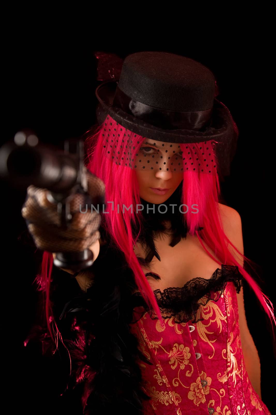 Attractive girl pointing gun at camera, isolated on black background 