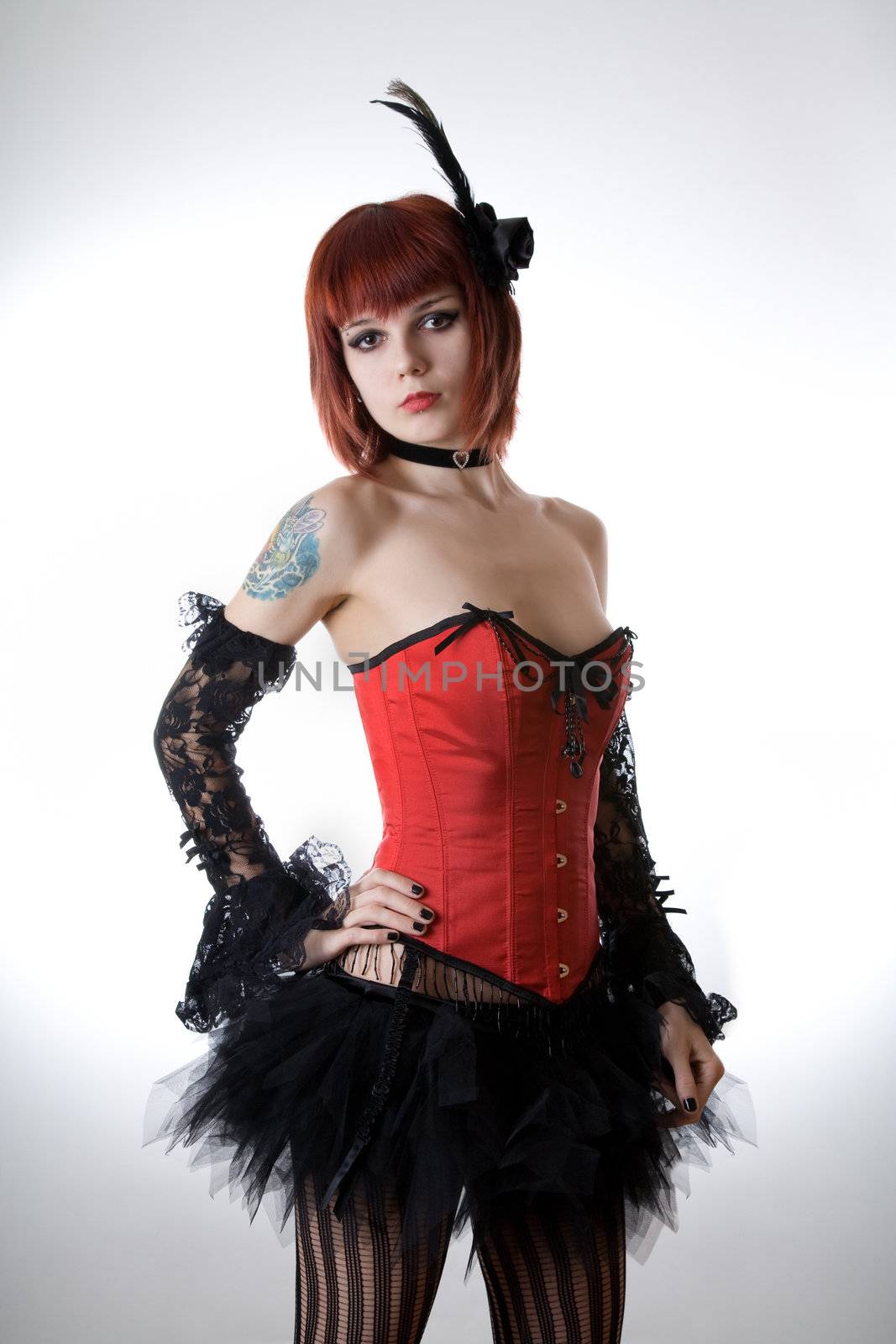 Cabaret girl in red corset, studio shot over light background 