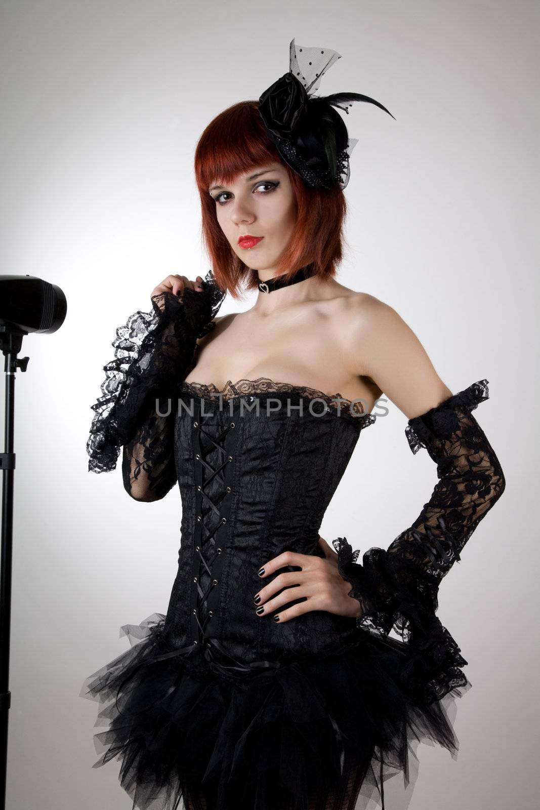 Attractive woman in black corset, gloves and tutu skirt, studio shot 