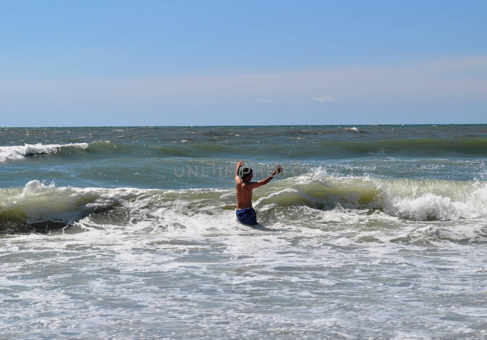 Teen playing in waves by RefocusPhoto