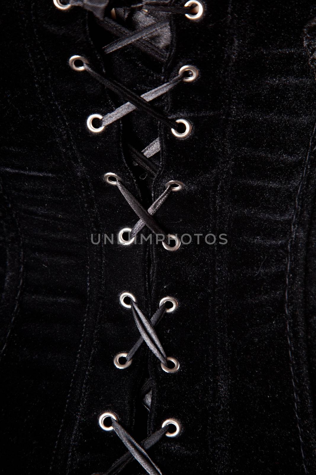 Close-up shot of black velvet corset lacing 