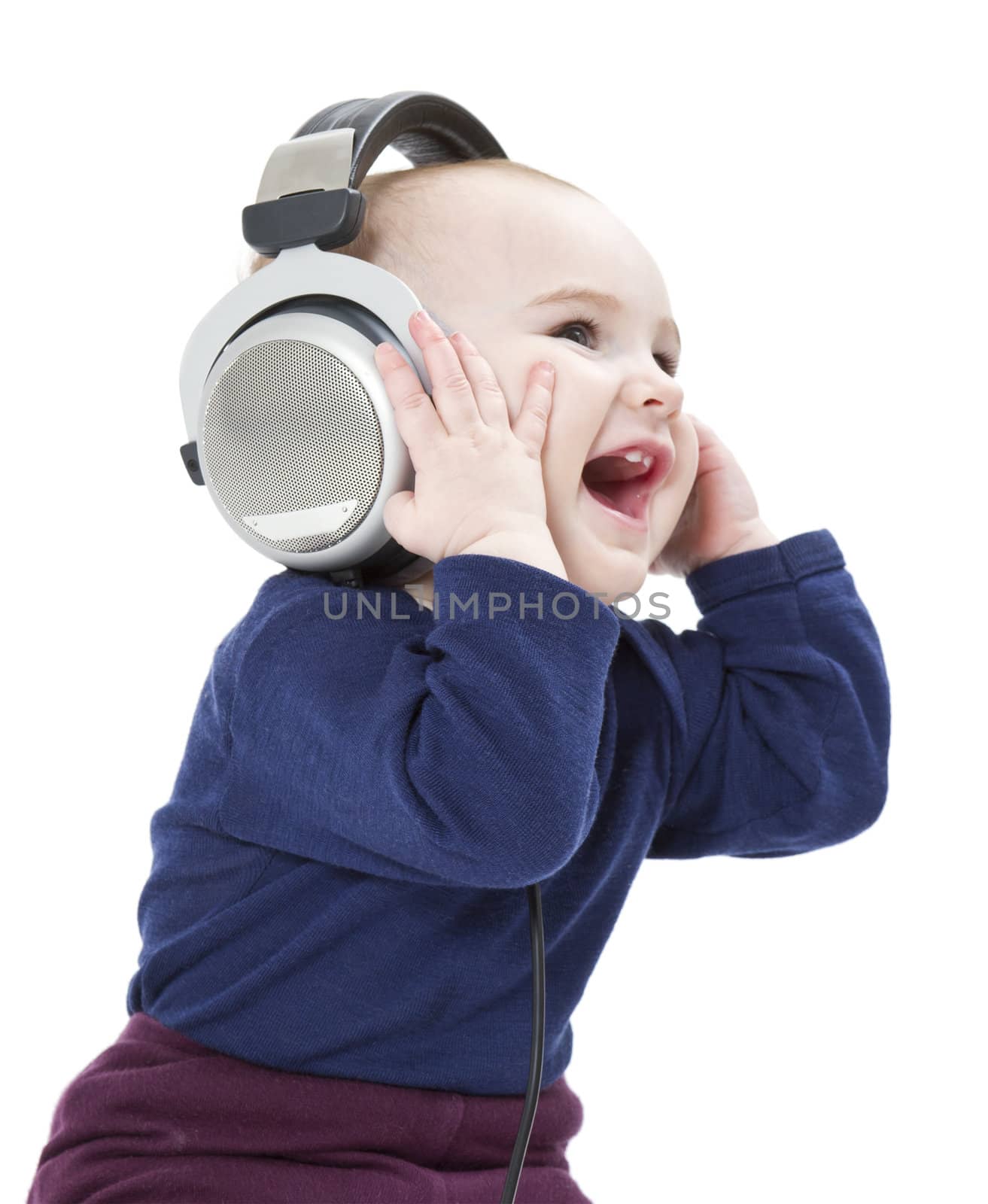 young laughing child with ear-phones listening to music by gewoldi