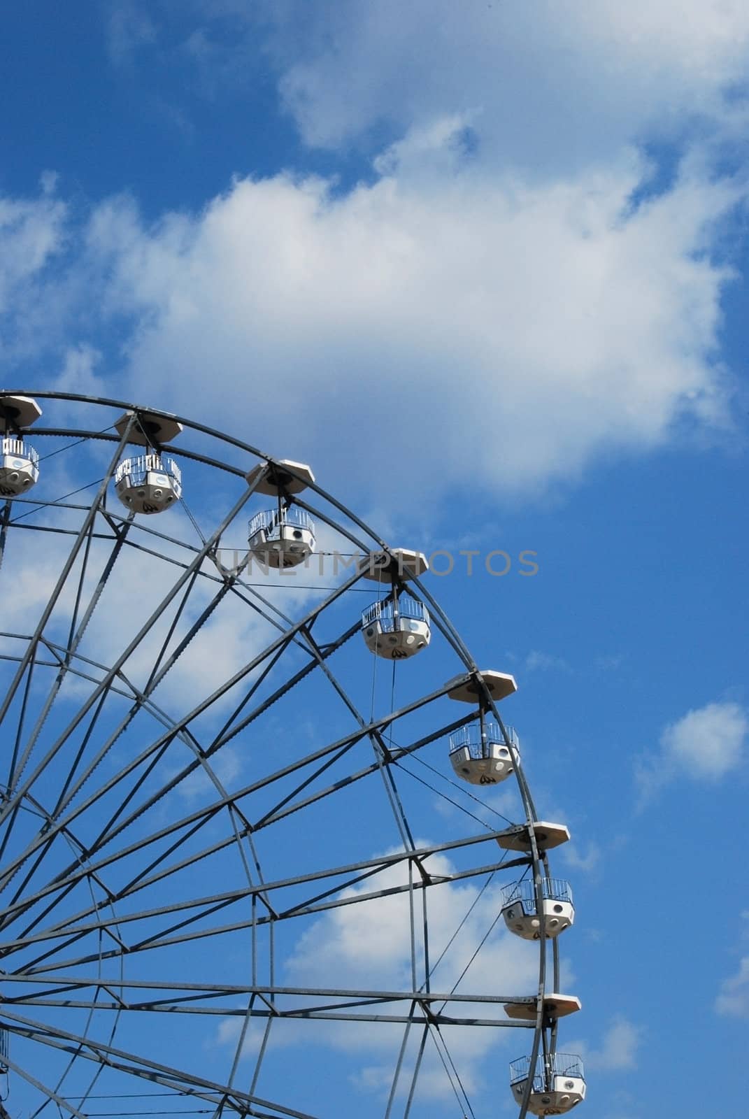 Part of Ferris wheel on blue sky background