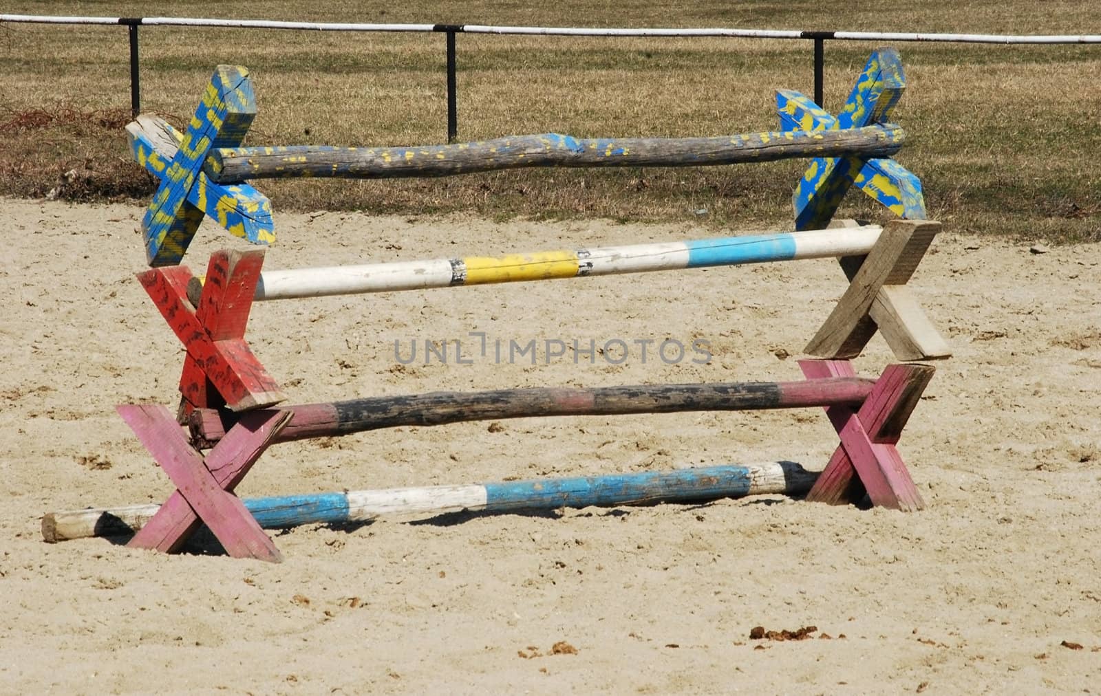 Painted wooden horse training hurdles on sand field