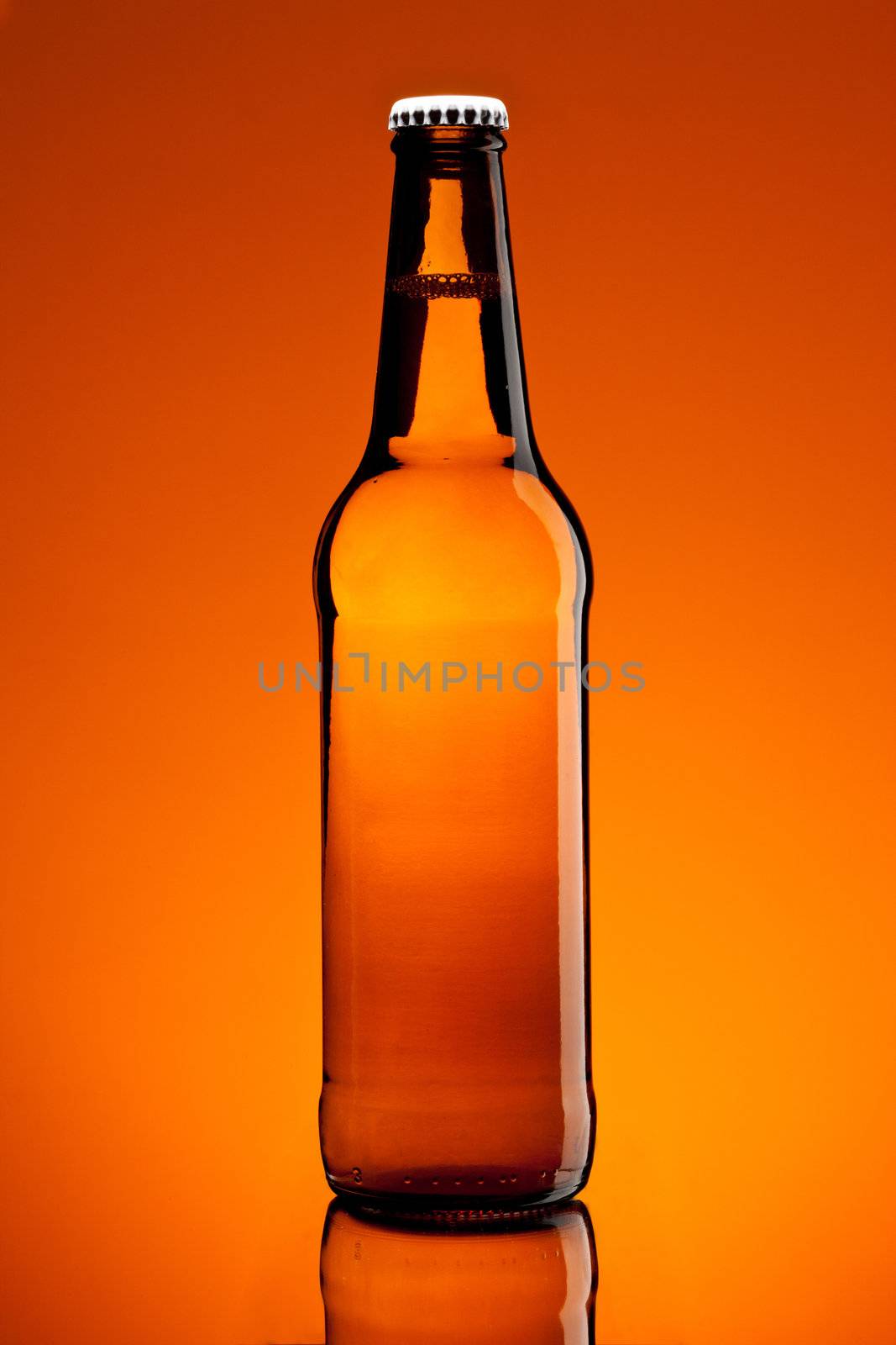 brown bottle with beer over brown background