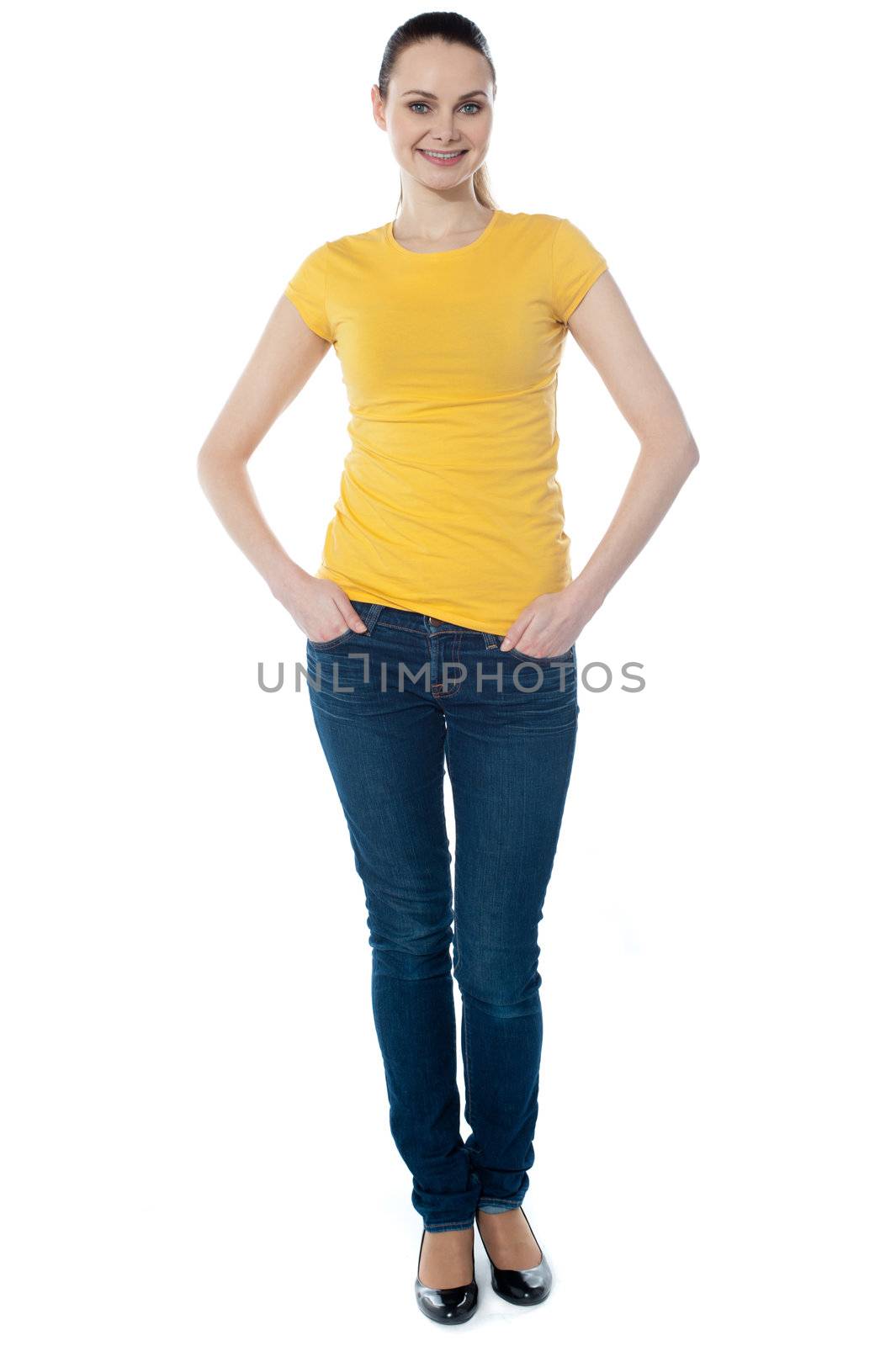 Portrait of a cute young girl standing with hands in pocket over white background