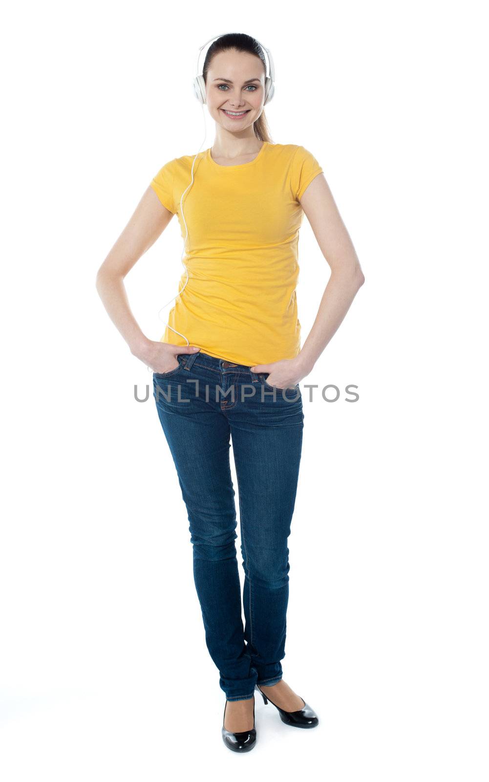 Portrait of a cute young girl standing with hands in pocket over white background