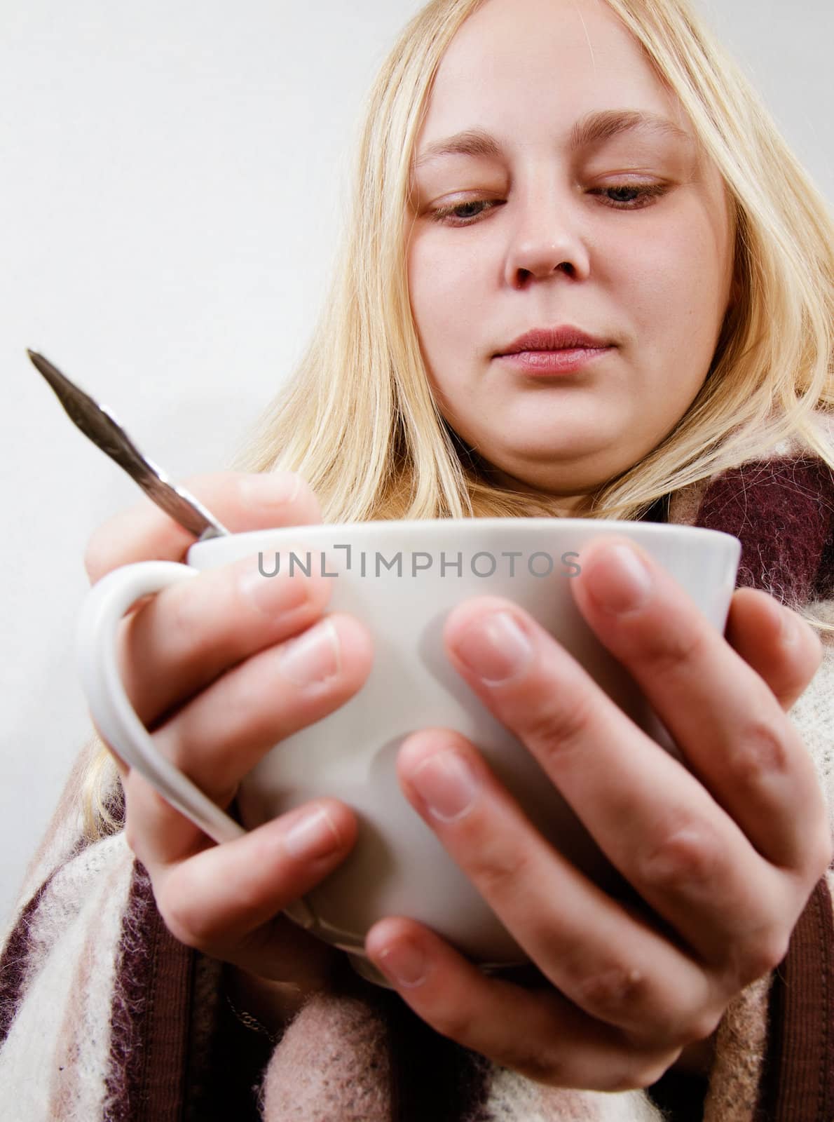 girl with a cup wrapped in a blanket. white background