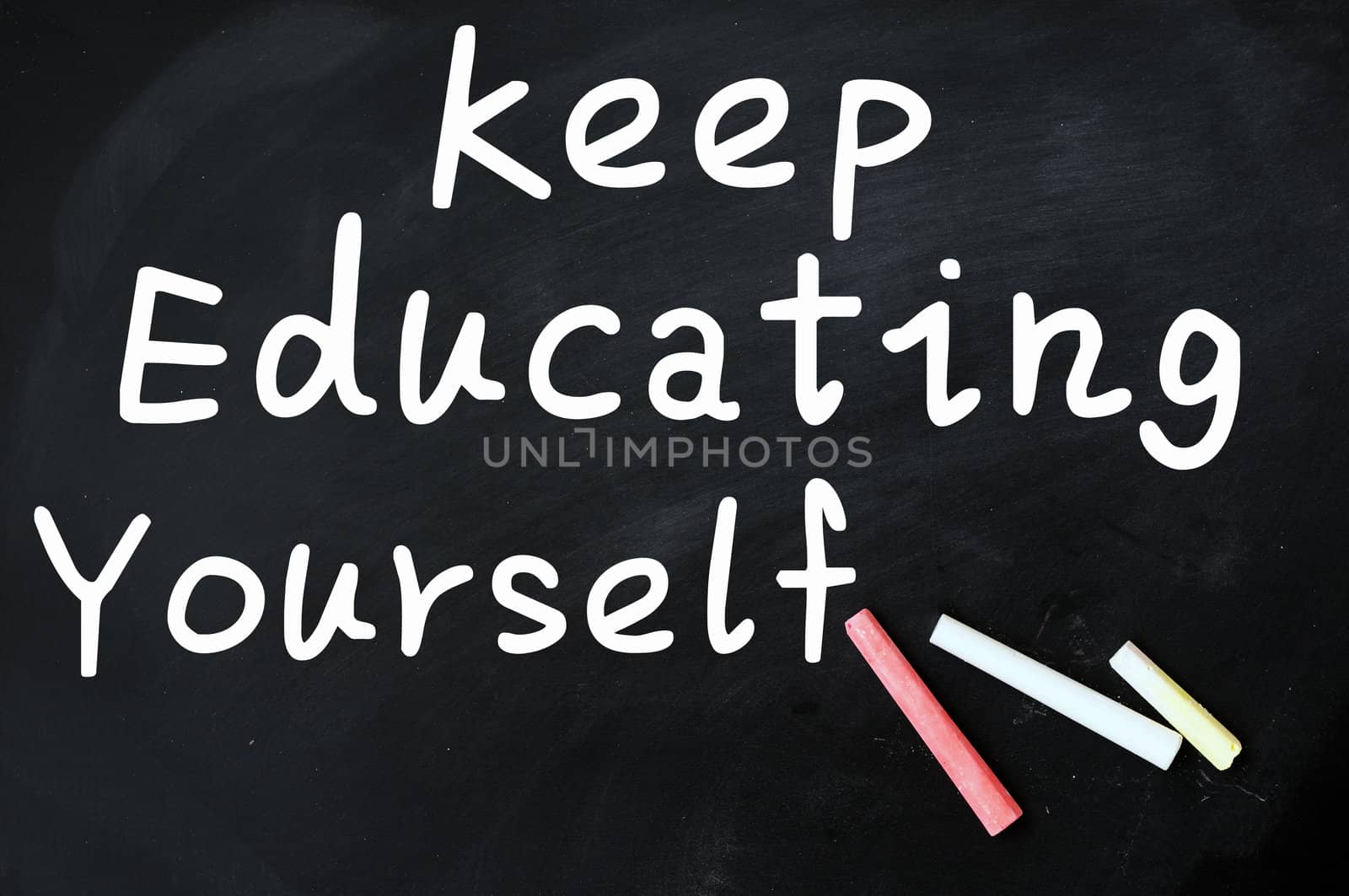 Acronym of KEY for Keep Education Yourself written with chalk on a blackboard