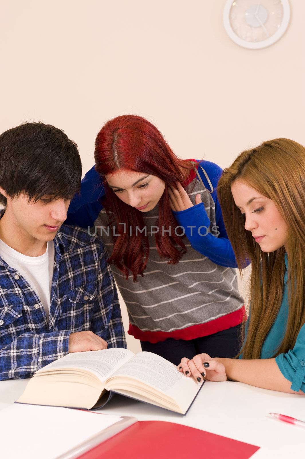 Teamwork in classroom, three concentrated students