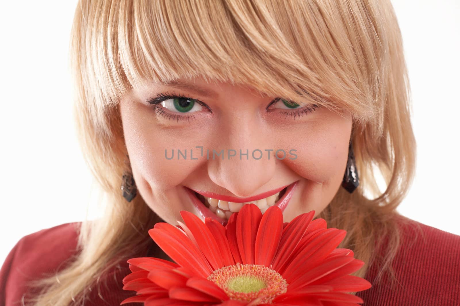 A smiling green-eyed woman in red with red flowers