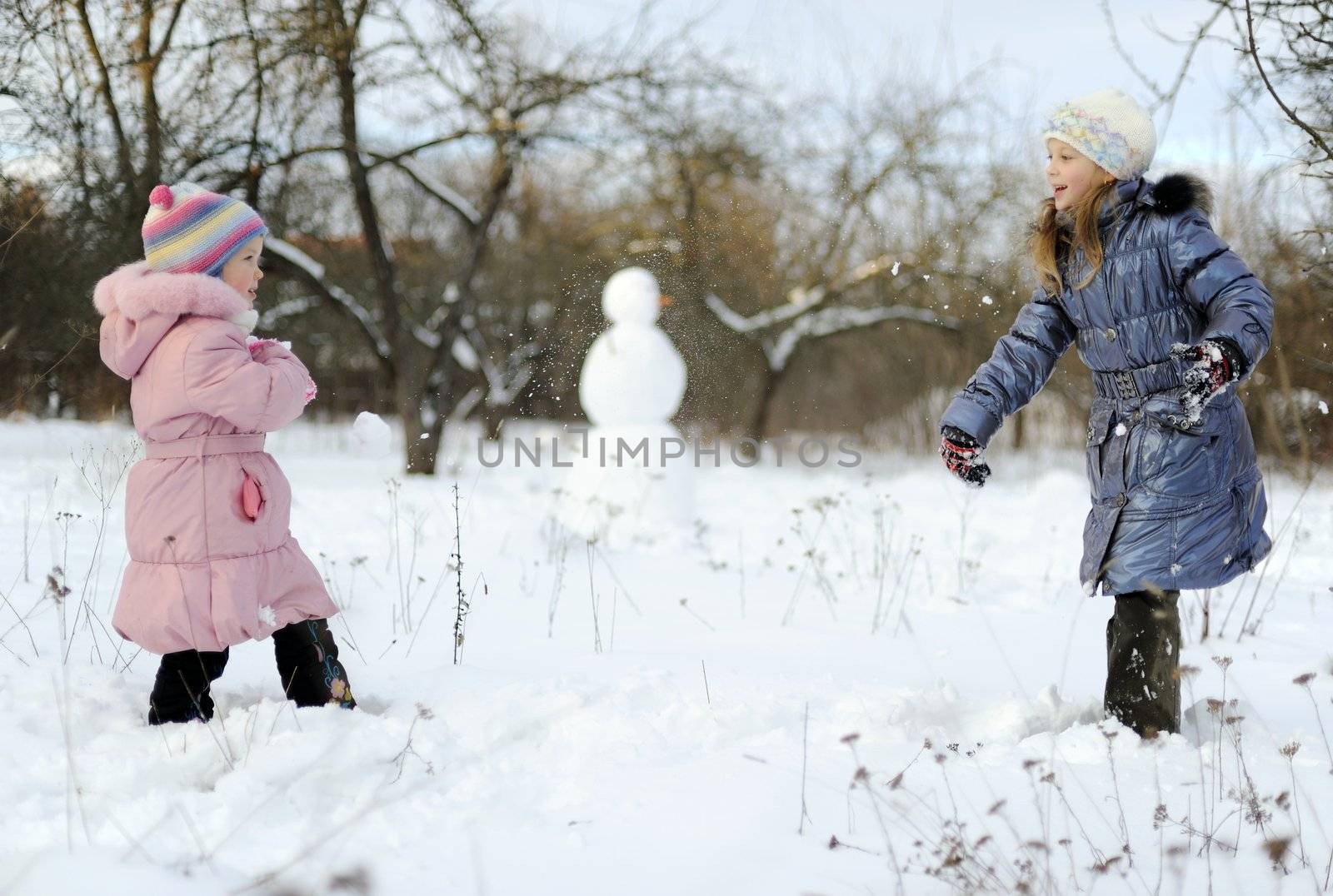 Little girls playing snowballs by velkol