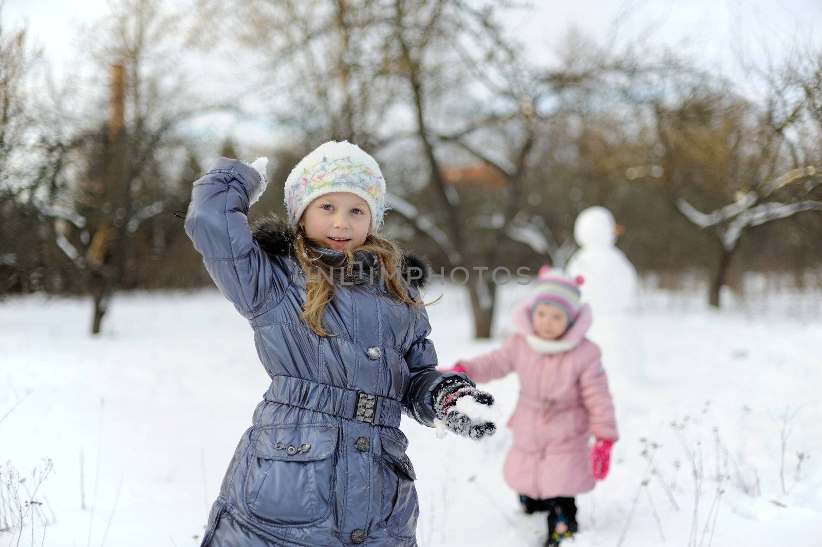 Two little girls playing snowballs by velkol