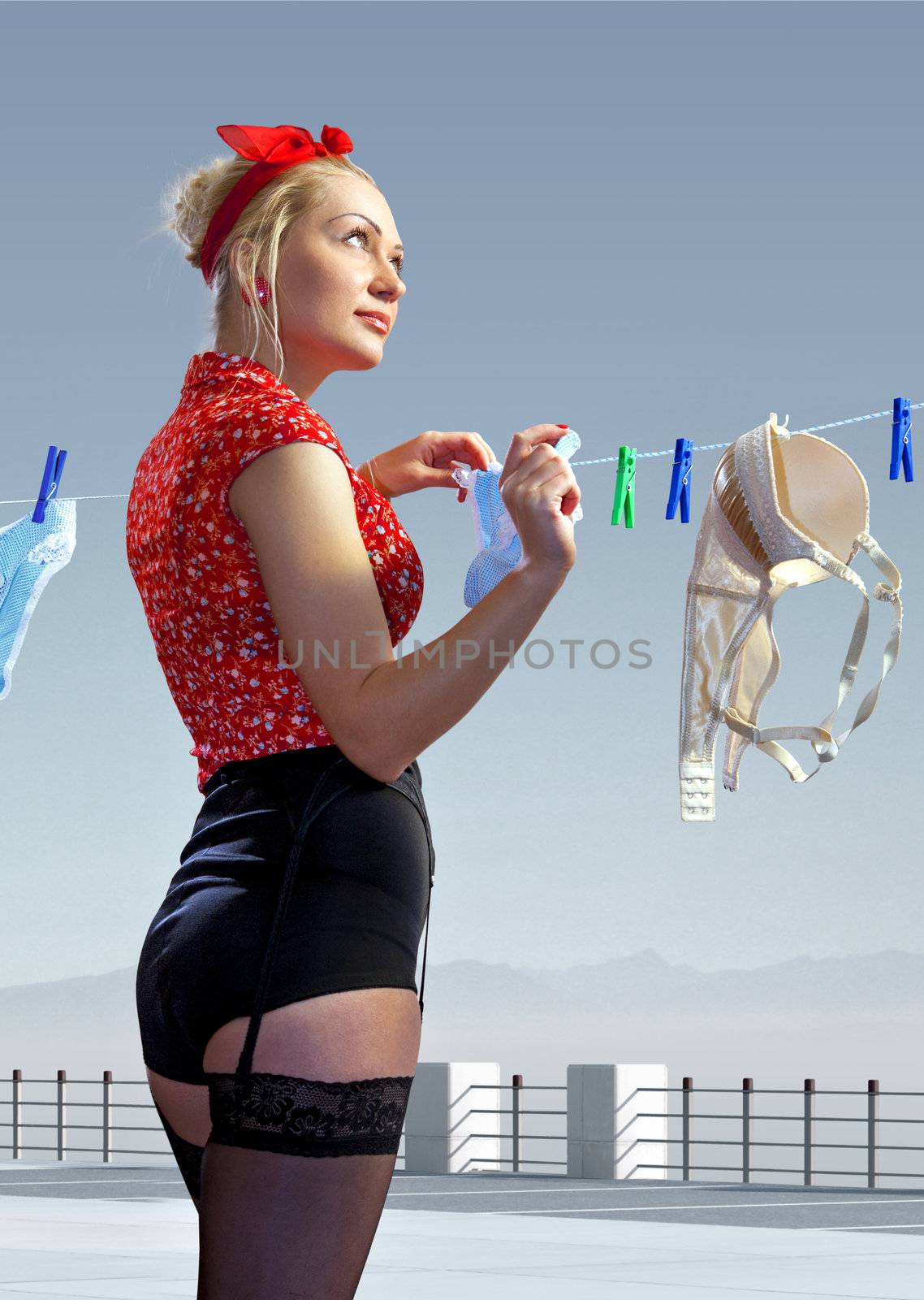beautiful housewife hangs out washed underwear for drying