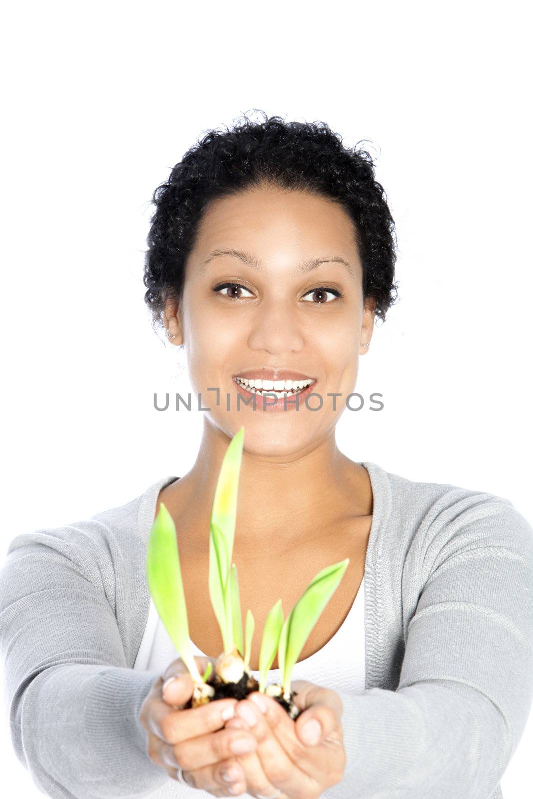 Happy young Afro-American woman holding a growing plant, on white background