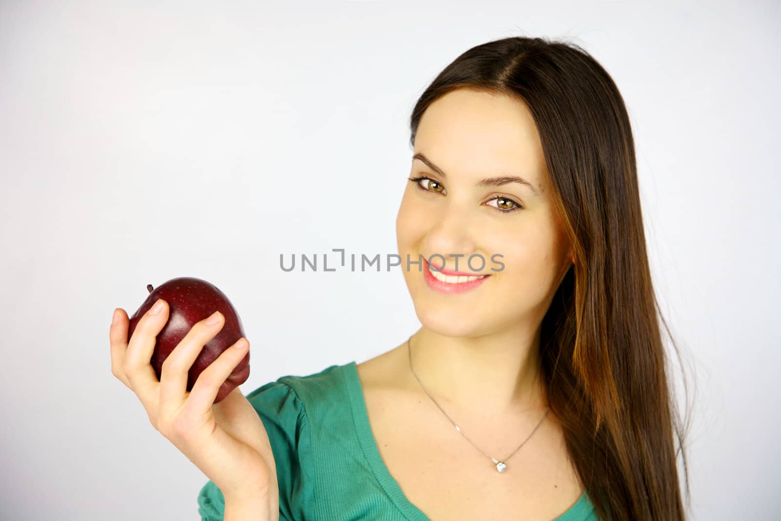 young girl smiling with red apple ready to eat it