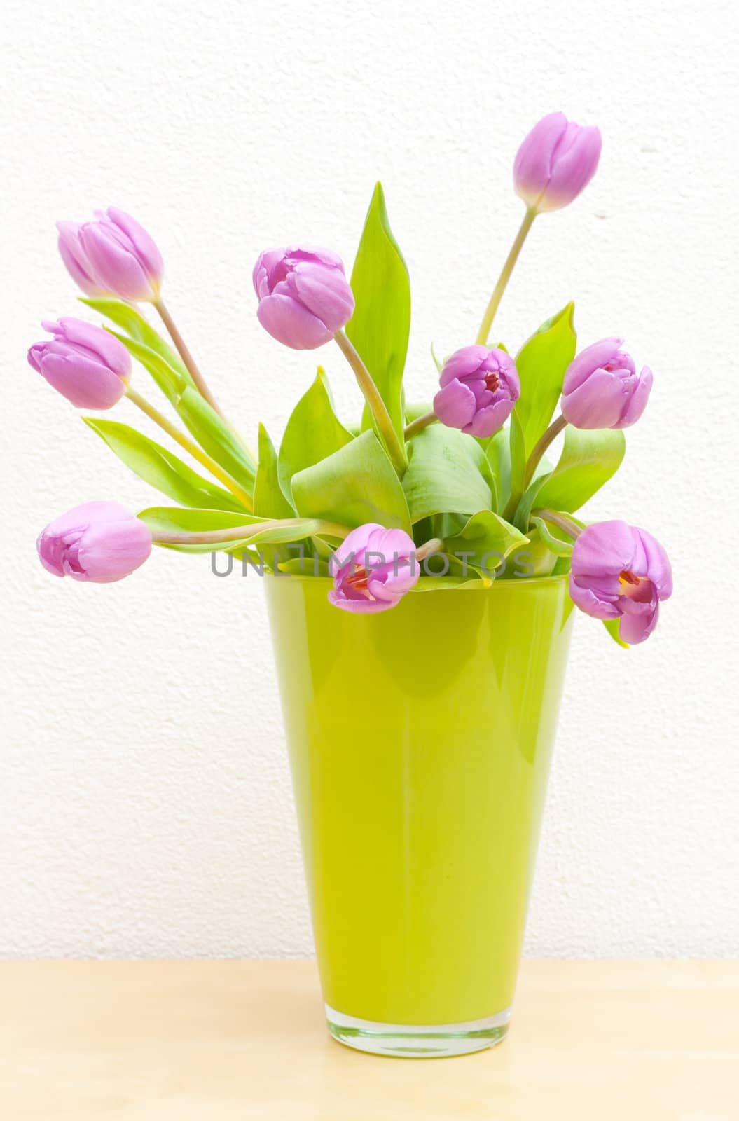 Pink Tulips Bouquet in Green Glass Vase on Wooden Table
