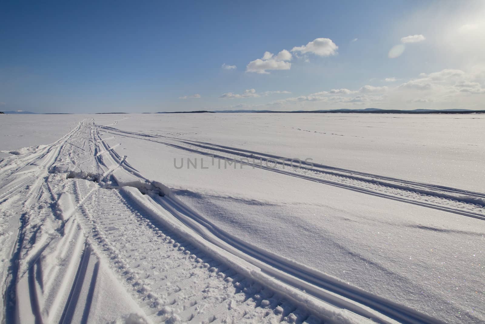 The crack in the ice on the sleigh track against the blue sky