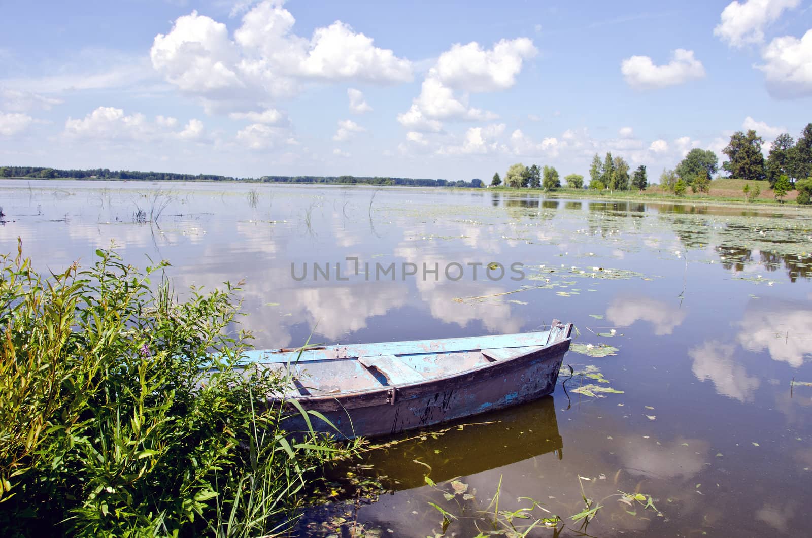 Spring lake fragment. Old boat moored on shore. by sauletas