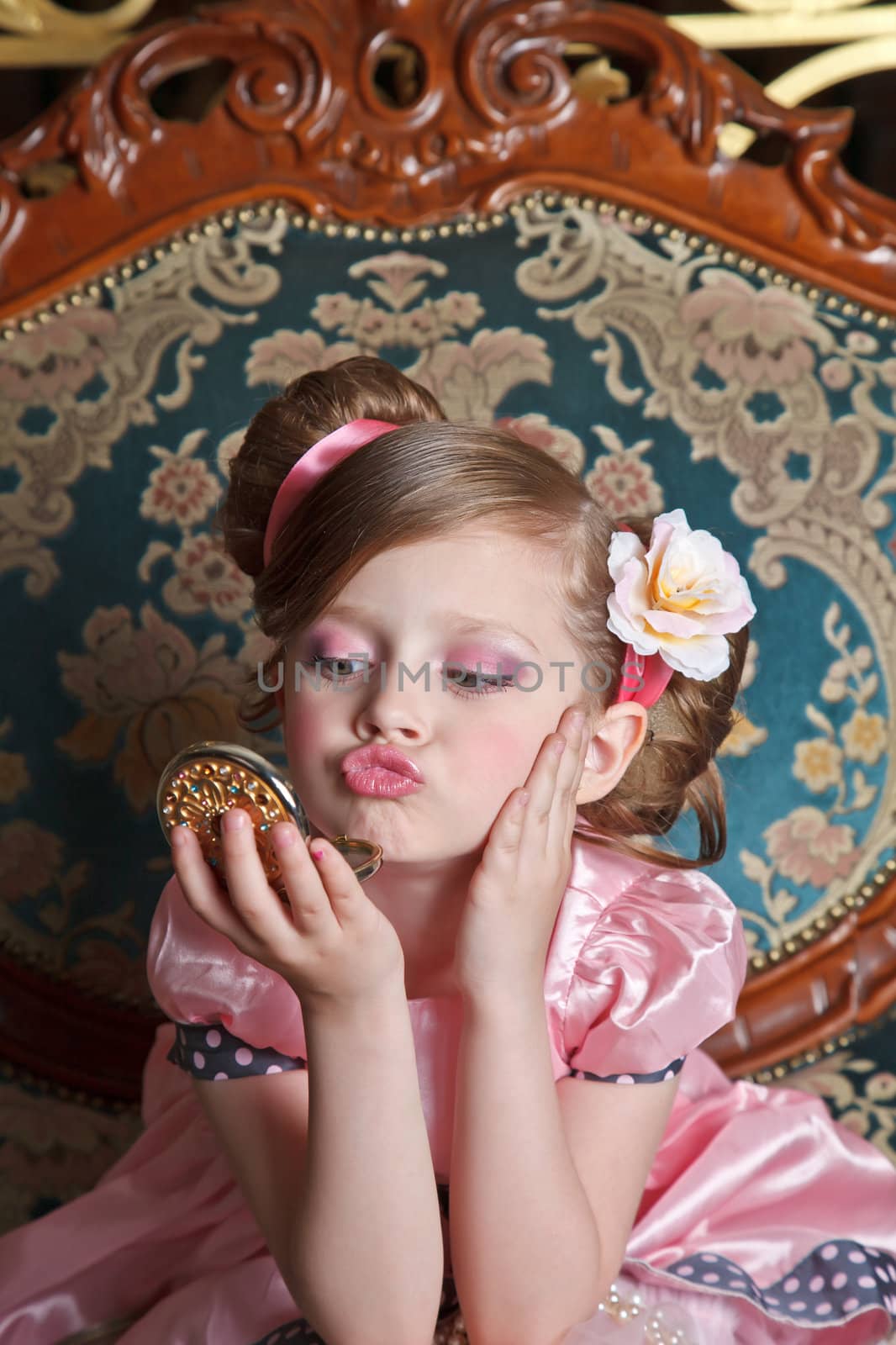 Portrait of a girl looking to the small mirror