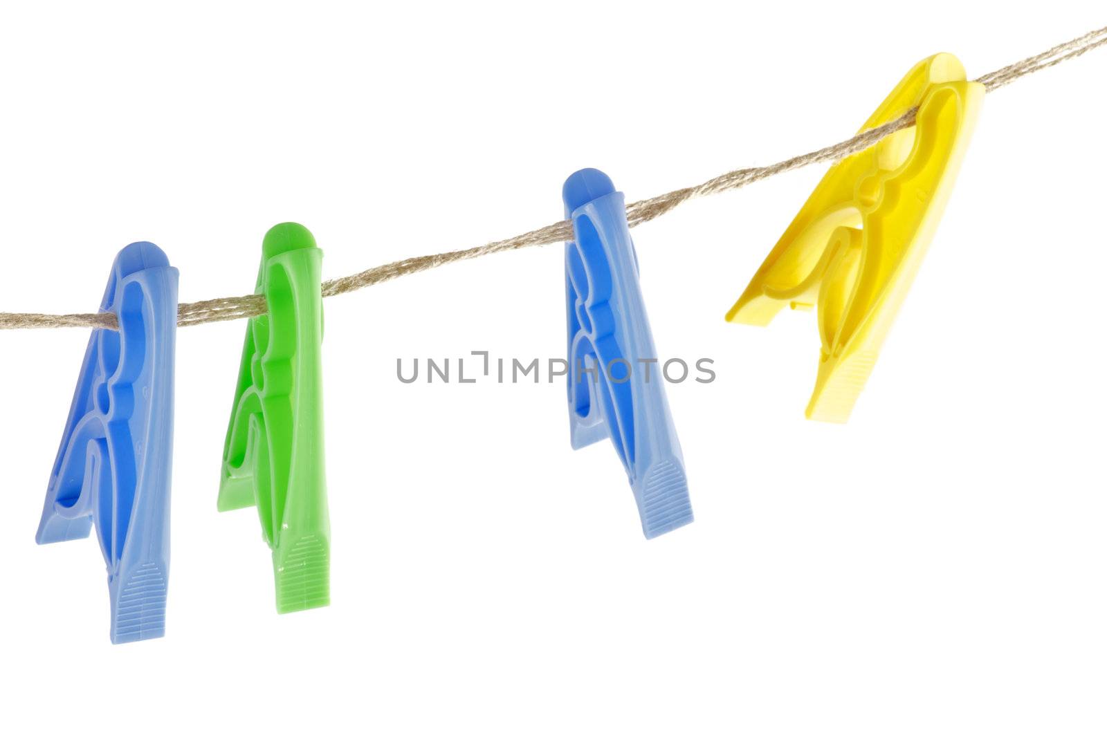 Four colour Clothespins on linen store isolated