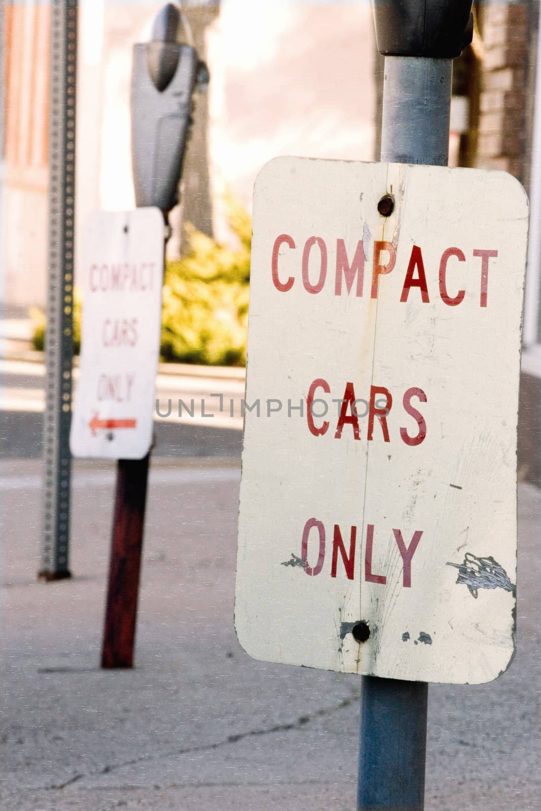 Compact cars only parking sign on urban street.